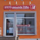Werbeschild mit Strahlern und Schaufensterbeschriftung - Tagwirkung