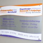Glasschild mit Wandabstandhaltern montiert und mit Folie beschriftet