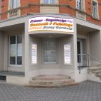 Werbeschild in Wellenform mit Folienbeschriftung auf einer gewölbten Fassade montiert