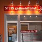 Werbeschild mit Strahlern und Schaufensterbeschriftung - Nachtwirkung